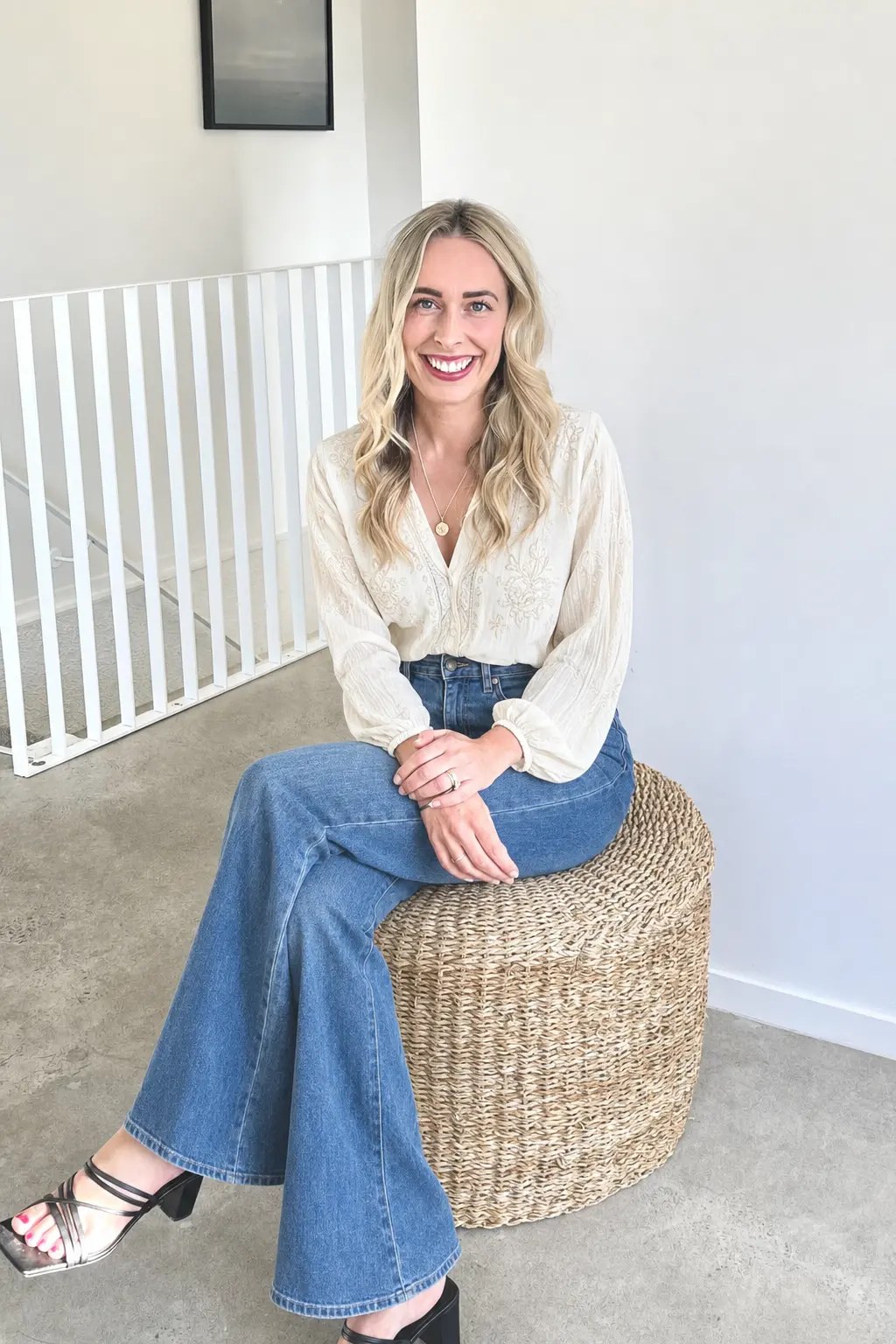 Aimee, founder of The Alignment Collective in Hamilton, sitting on a woven stool in a bright studio